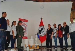 Representantes reunidos junto a materiales donados para el complejo cultural
